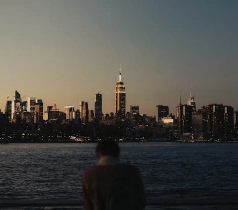 Person gazing at the New York skyline at night